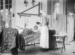 A patient, his arm in a weighted arm rest, and nurse on the verandah at the Duchess of Westminster's Convalescent Red Cross No 1 Hospital at Le Touquet.