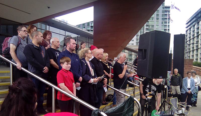 on the apron of the Manchester Central Convention Centre ... Reading the names of those killed